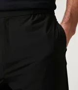 Pantalón de vestir negro, de corte slim cropped, con cintura elástica, cierre con cremallera y bolsillos laterales.