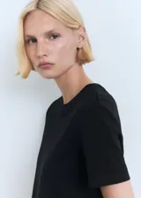 Remera negra de algodón, de corte recto, manga corta y cuello redondo.