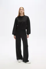 Pantalón de poliéster color marrón, de corte recto y tiro alto con pinzas frontales.