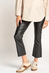 Pantalón negro de corte flare, tiro medio y efecto encerado.