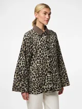 Chaqueta de denim con estampado animal print, cuello marrón y botones negros.
