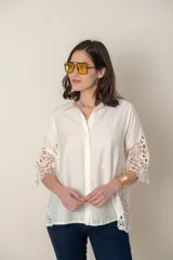Camisa color blanco con apliques de guipiur en costados y mangas, de calce holgado.