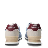 Championes urbanos New Balance modelo 574, color azul claro y azul medio, con detalles en beige, burdeos y blanco. Confeccionados en gamuza y malla, con logo "N" característico en los laterales y entresuela ENCAP.