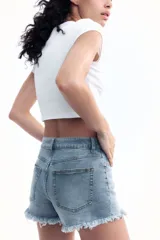 Short de jean celeste con tiro alto, cinco bolsillos y ruedo desflecado.