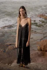 Vestido largo negro de seda con breteles finos y escote en V con puntilla. Estampado con motivos astrológicos dorados.