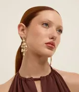 Caravana de metal reciclado con baño dorado claro, de tamaño mediano. Presenta un diseño de flecos compuesto por esferas con efecto martillado y cierre de tornillo.