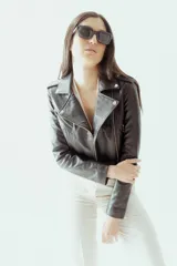 Campera corta de cuero ovino negro, estilo motoquera, con cierre asimétrico, cuello con solapas y múltiples bolsillos con cierre.