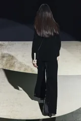 Camisa negra de terciopelo con cuello solapa, manga larga con puños en tejido color crema a contraste y bajo redondeado.