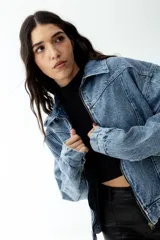 Campera de jean celeste con lavado ácido, corte cropped y cierre frontal con cremallera metálica.