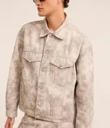 Campera masculina de sarga con estampa abstracta, corte boxy, cuello inglés, manga larga con puños abotonados, cierre frontal abotonado y bolsillos delanteros.