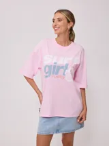 Remera rosa de algodón con estampado frontal con la frase 'Surf girl' y logo de la marca Rusty. Corte oversize.