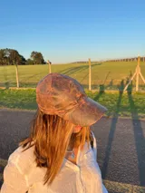 Set de tres gorras de cuero con viseras de diferentes colores: marrón oscuro, verde oliva y rojo ladrillo. La gorra superior tiene un bordado sutil en hilo claro.