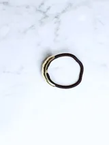 Colita de pelo con aplique dorado texturizado.