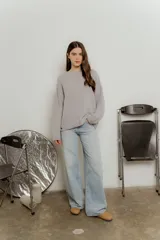 Sweater de punto color gris claro, de corte holgado y mangas largas.