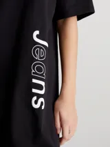 Vestido corto negro de corte recto, con cuello redondo y mangas cortas. Estampado vertical con el logo de Calvin Klein Jeans en color blanco.