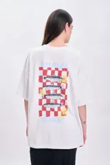 Remera blanca de corte oversize con estampado en la espalda que incluye la frase 'Amalfi Coast', un diseño a cuadros rojos y dibujos de sardinas con rodajas de limón.