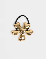 Gomita de pelo elástica negra con aplique de flor dorada de metal.