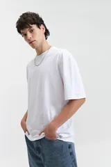 Remera blanca de algodón, corte oversize, manga corta y cuello redondo.