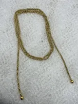 Collar dorado de cadena fina con eslabones de bolitas y terminaciones con bolitas más grandes.