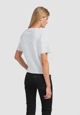 Remera color verde con estampado de una pierna con zapato de tacón y corazones.