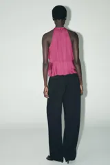 Top color fucsia de cuello halter con volantes en el mismo tejido. Cierre en la espalda con abertura y botones.