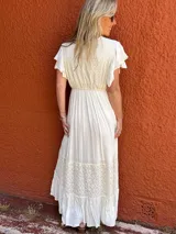 Vestido largo color crudo, de seda con bordados en el mismo tono, escote en V, mangas cortas con volados y corte imperio.