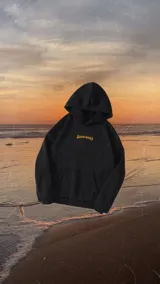 Hoodie negro con estampado en la espalda con palmeras, sol y texto "Classy Waves".