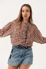 Minifalda de jean azul claro con corte evasé, detalle de short interno y cinturón negro con argollas metálicas.