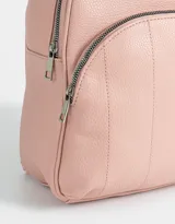Mochila pequeña de cuerina color rosa, con bolsillo frontal acolchado, correas regulables y manija superior.