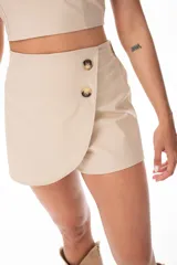 Short pollera color beige con cierre cruzado con botones.