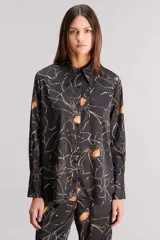 Camisa de satén liviano con calce regular y mangas largas. Estampada con diseño floral en tonos naranja, blanco y negro.