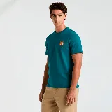 Remera de manga corta color azul petróleo con cuello redondo y estampado pequeño en el pecho.