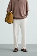 Pantalón color arena de corte recto, confeccionado en tejido de algodón y lino. Cuenta con cintura elástica ajustable con cordón, bolsillos delanteros y traseros de parche.