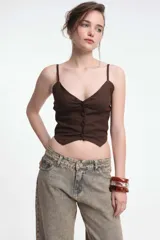 Top negro con breteles finos, escote en V y abotonadura frontal.