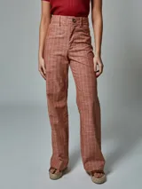 Pantalón de lino color ladrillo con estampado a cuadros blancos, de corte palazzo y tiro alto.