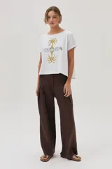 Remera blanca de algodón con estampa de palmeras y la palabra "Sunrise" en el frente.