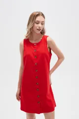 Vestido blanco de lino, corte entallado, con botones frontales, cuello a la base y breteles anchos.