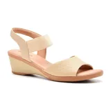 Sandalia de cuero color beige, con plataforma baja y tira elástica en el tobillo.