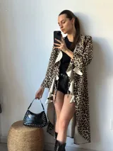 Maxi camisa con estampado animal print de leopardo, con cuello camisero, mangas largas con puños abotonados y volados en el frente.