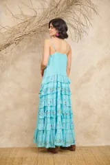 Vestido largo blanco con breteles finos ajustables, corte imperio, volados en vainilla y bordados florales.