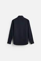 Camisa blanca de corte regular, cuello italiano, manga larga con puños abotonados y cierre frontal con botones.