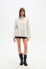 Sweater de viscosa color beige, con cuello polera, corte holgado y pespuntes decorativos en el frente.