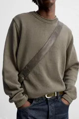 Jersey color beige de punto con cuello redondo y manga larga.