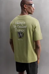 Remera verde oliva de corte relaxed fit, cuello redondo y manga corta. Tiene un pequeño logo estampado en el bajo.