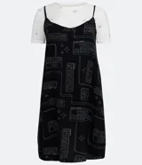 Vestido corto negro con estampado de palabras en blanco y remera blanca de manga corta con estampado de estrellas.