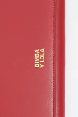 Billetera de estructura rígida color negro con logo metálico dorado de la marca Bimba y Lola en el frente. El interior cuenta con tarjetero y monedero con cierre de cremallera.