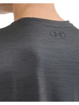 Remera deportiva gris de Under Armour, holgada y ligera, con paneles de malla transpirable y tejido elástico en cuatro direcciones.