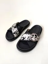 Sandalias negras con tiras cruzadas de cuero vacuno y estampado animal print, hebilla metálica y suela de goma.