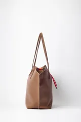 Bolso de símil cuero color marrón con interior forrado y necessaire incluido.