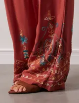 Pantalón verde oliva de rayón con cintura elastizada tipo smock y bordados florales en los bajos.